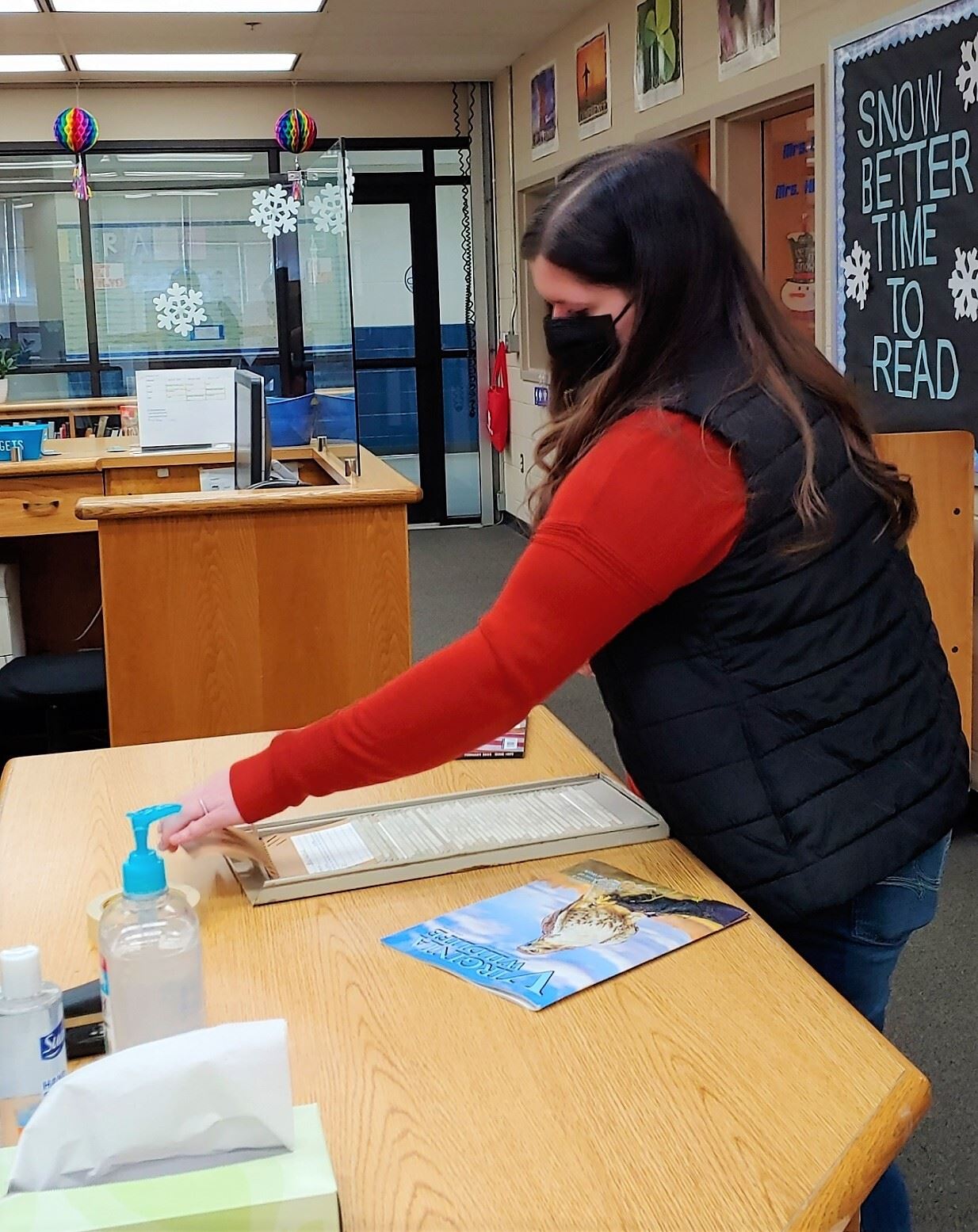 Student checking in magazines in library